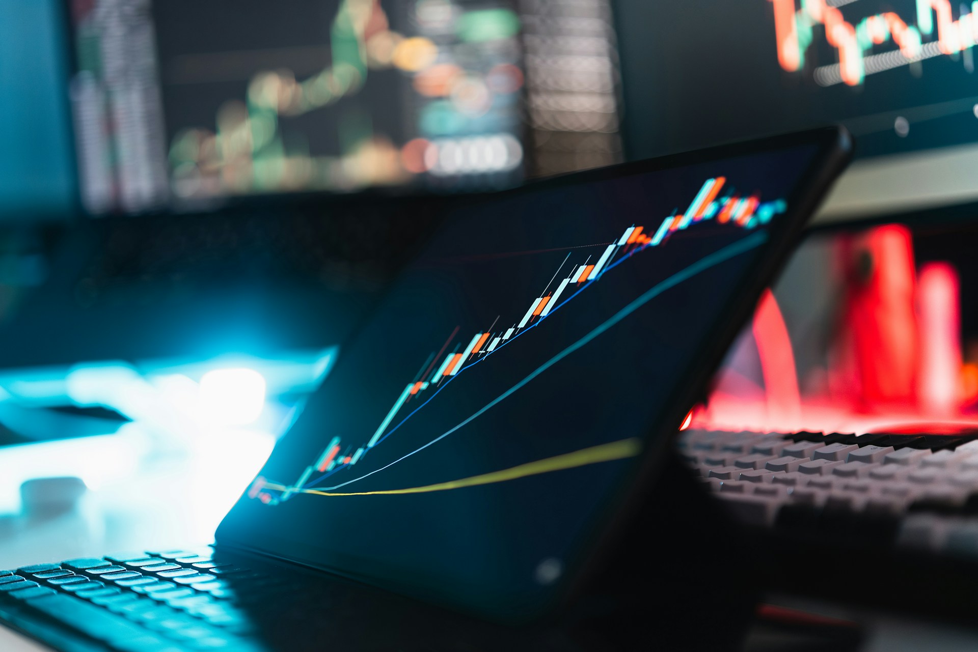 Laptop displaying stock market chart and business data